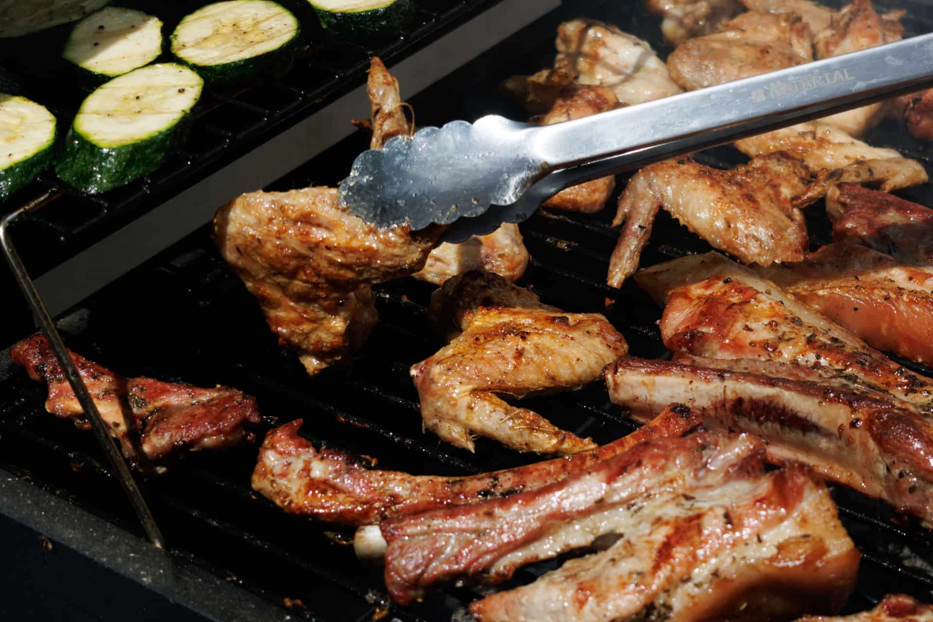 Barbecue grilling tools laid out beside a grill